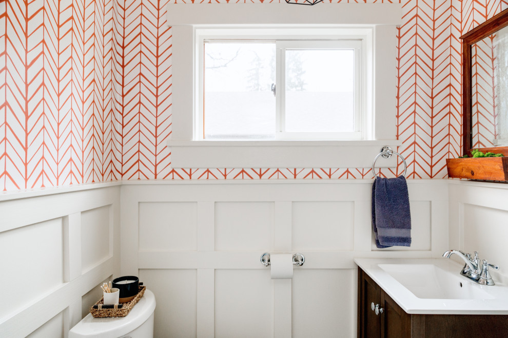 Mid-sized trendy 3/4 ceramic tile, gray floor, single-sink and wall paneling bathroom photo in Denver with flat-panel cabinets, dark wood cabinets, solid surface countertops, white countertops, a freestanding vanity, a one-piece toilet, orange walls and an integrated sink