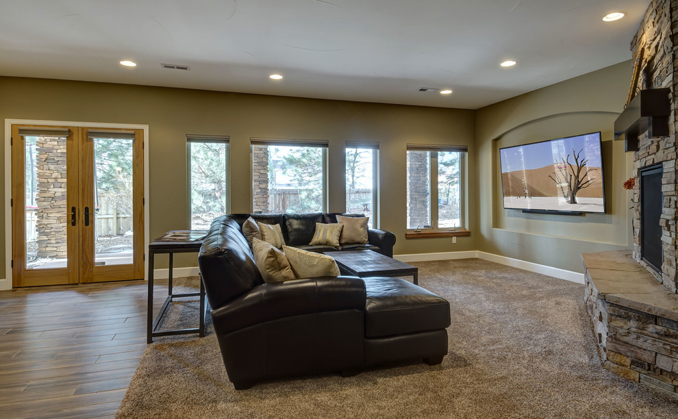 This is an example of an expansive transitional walk-out basement in Denver with beige walls, carpet, a corner fireplace, a stone fireplace surround and brown floor.