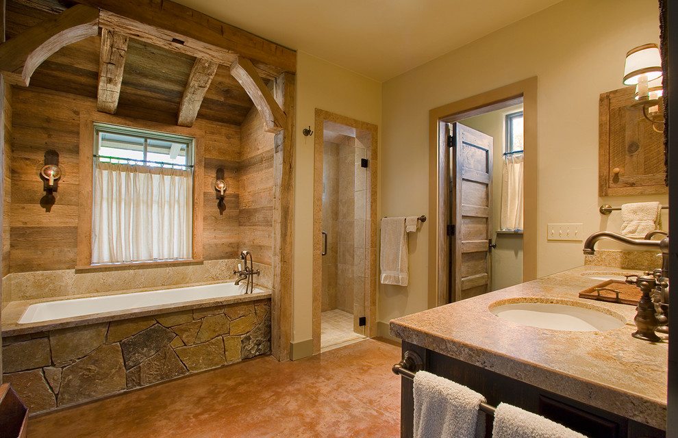 Freestanding bathtub - large rustic master beige tile concrete floor freestanding bathtub idea in Austin with dark wood cabinets, a two-piece toilet, gray walls and a console sink