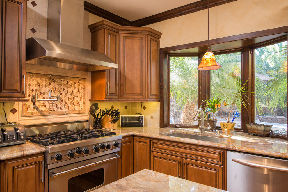 Inspiration for a large mediterranean u-shaped separate kitchen in San Diego with a drop-in sink, recessed-panel cabinets, medium wood cabinets, granite benchtops, beige splashback, terra-cotta splashback, stainless steel appliances, medium hardwood floors and with island.