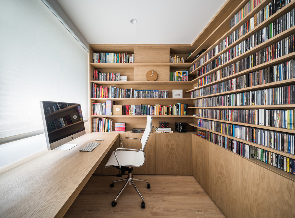 Contemporary home office in Other with light hardwood floors, a built-in desk and beige floor.