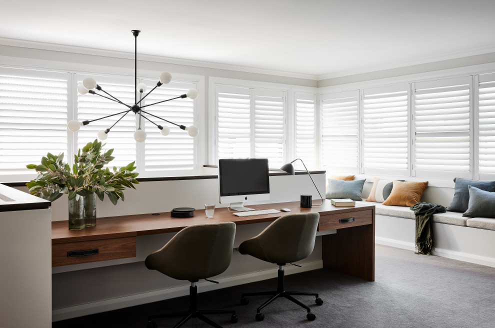 Cette photo montre un grand bureau tendance avec un mur blanc, moquette, aucune cheminée, un bureau intégré et un sol beige.