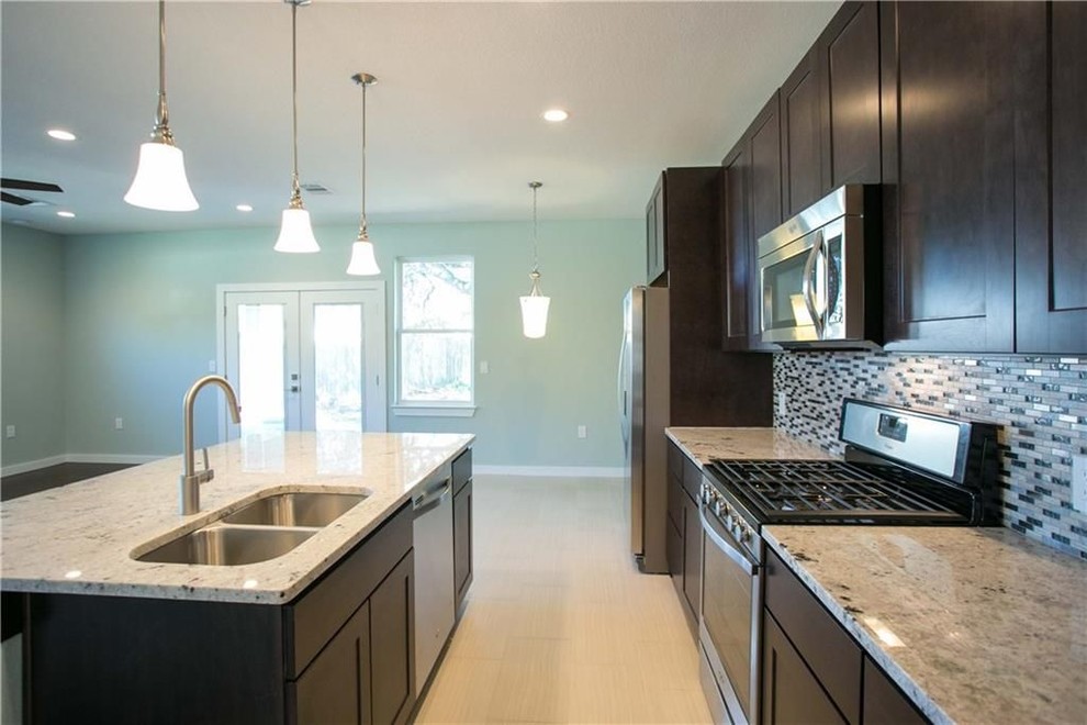 Example of a mid-sized transitional single-wall porcelain tile and beige floor eat-in kitchen design in Austin with a double-bowl sink, shaker cabinets, dark wood cabinets, granite countertops, gray backsplash, mosaic tile backsplash, stainless steel appliances, an island and gray countertops