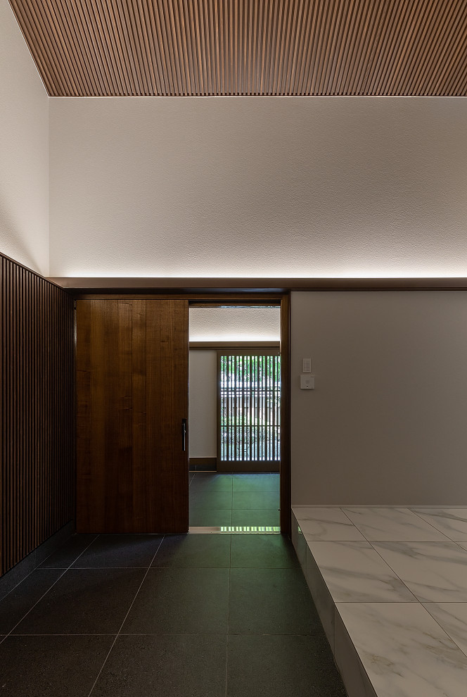 Aménagement d'une grande entrée asiatique avec un couloir, un mur blanc, un sol en carrelage de céramique, une porte coulissante, une porte marron, un sol blanc, un plafond en lambris de bois et du papier peint.