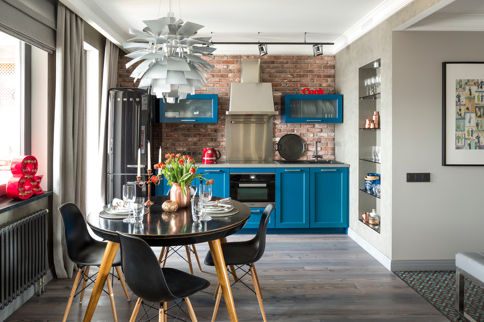 This is an example of a mid-sized industrial single-wall open plan kitchen in Moscow with black appliances, dark hardwood floors, a drop-in sink, recessed-panel cabinets, blue cabinets, brown splashback and no island.