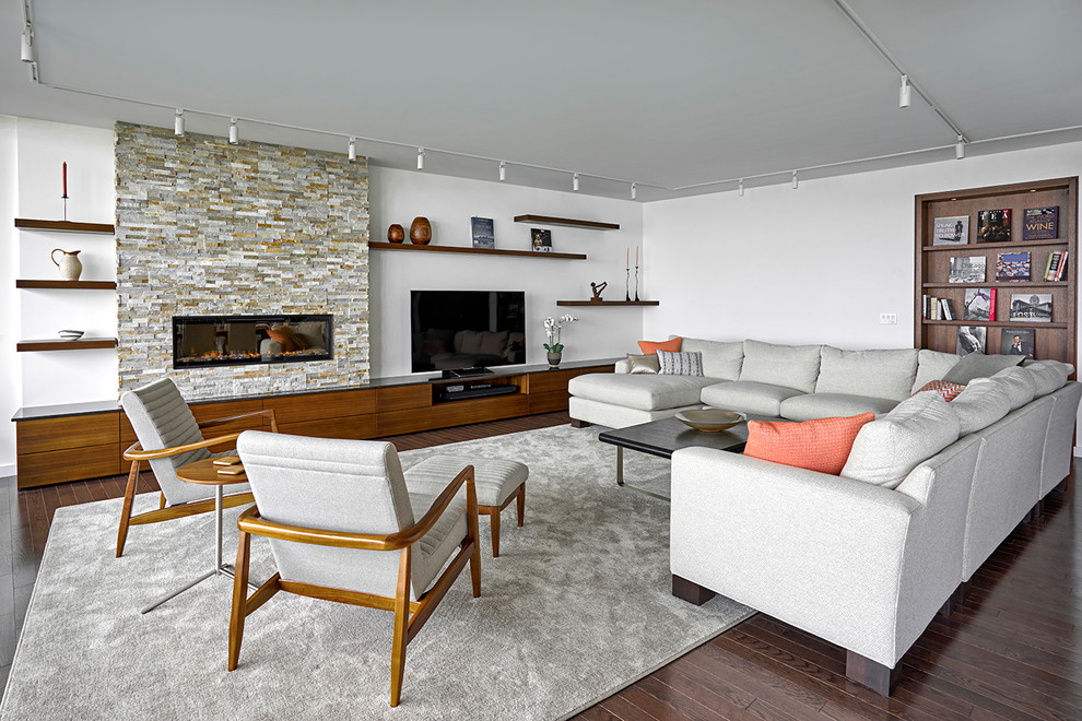 Photo of a large modern formal open concept living room in Chicago with white walls, brown floor, dark hardwood floors, a ribbon fireplace, a stone fireplace surround and a built-in media wall.