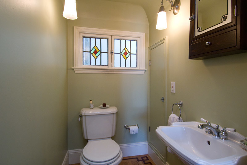 Traditional 3/4 bathroom in San Francisco with a two-piece toilet, green walls and a wall-mount sink.