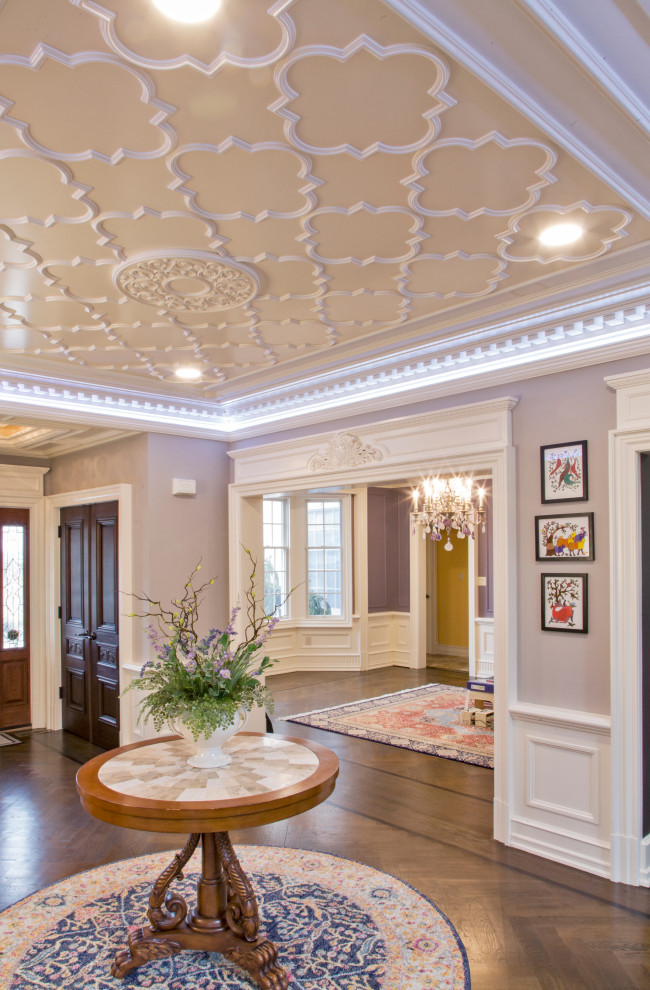 This is an example of a mid-sized traditional foyer in New York with white walls, medium hardwood floors, a double front door, a brown front door, brown floor, coffered and panelled walls.