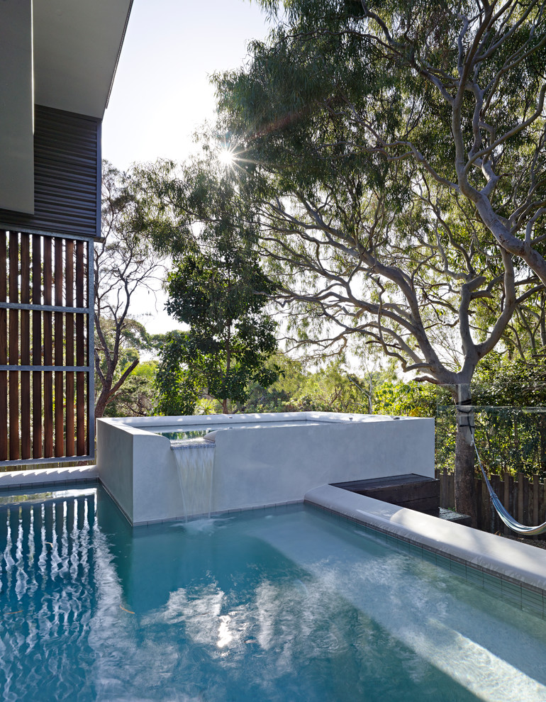 This is an example of a large contemporary custom-shaped pool in Sunshine Coast with a water feature.