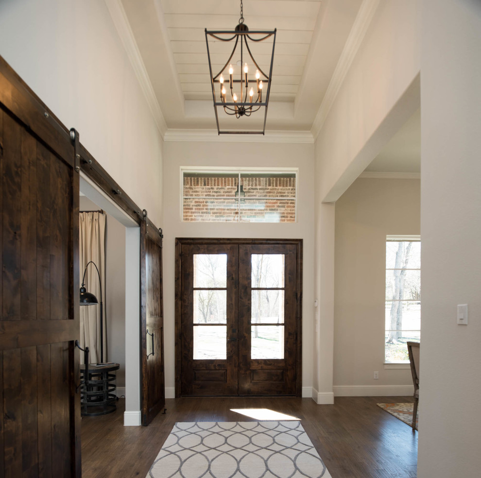 Inspiration for a large transitional brown floor and medium tone wood floor foyer remodel in Dallas with beige walls and a dark wood front door
