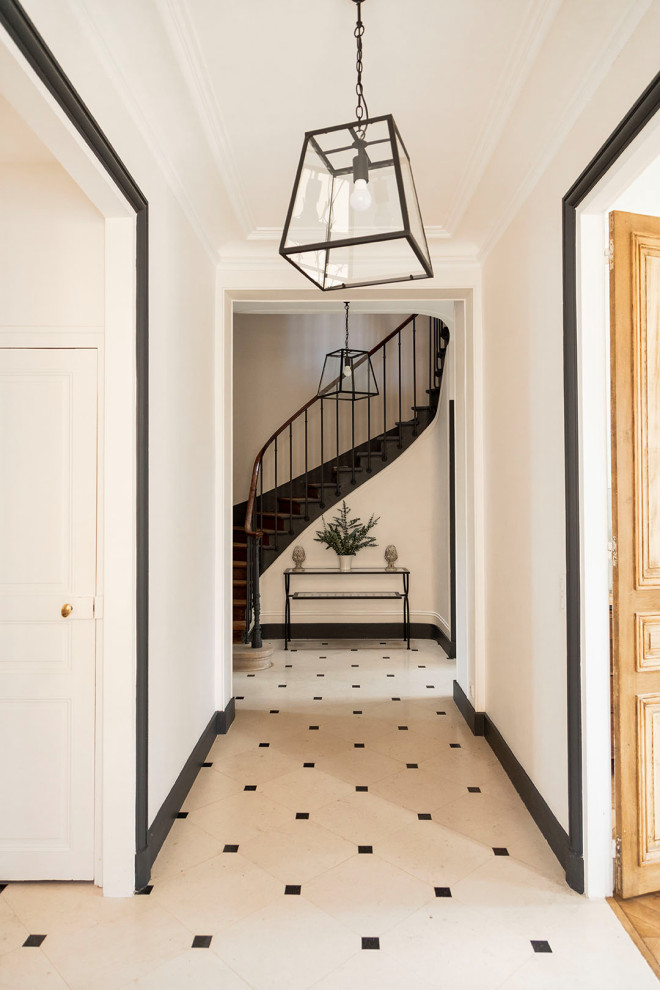 This is an example of a large traditional hallway in Paris with white walls, porcelain floors and white floor.