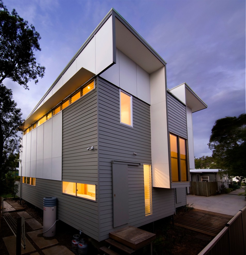 Photo of a contemporary two-storey grey exterior in Sunshine Coast with mixed siding and a flat roof.