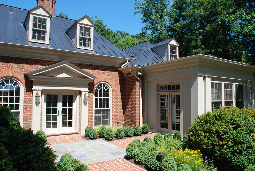 Design ideas for a large traditional two-storey brick red house exterior in DC Metro with a hip roof and a metal roof.