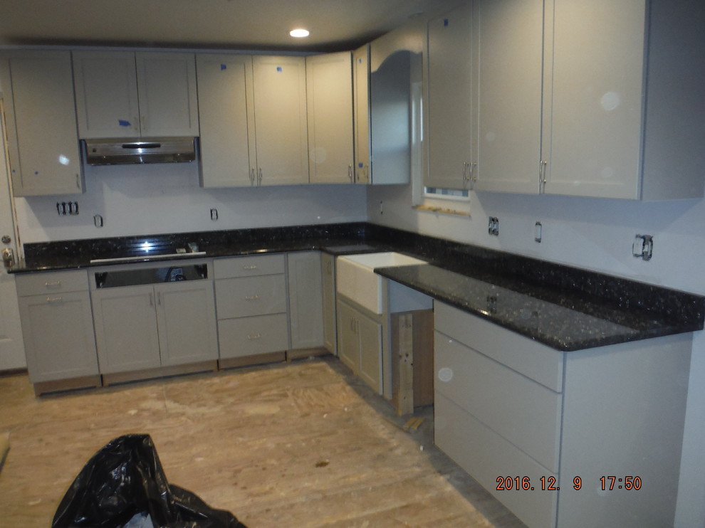 Example of a mid-sized transitional l-shaped kitchen design in Baltimore with a farmhouse sink, shaker cabinets, gray cabinets, quartz countertops, stone slab backsplash, stainless steel appliances and no island