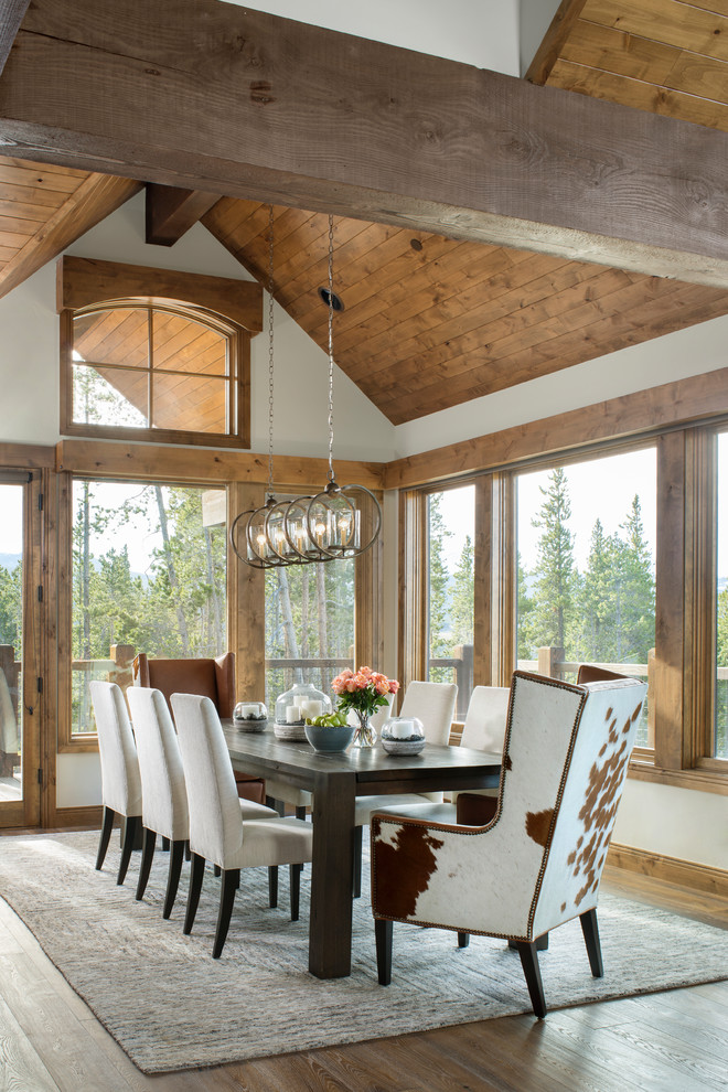 Design ideas for a country dining room in Denver with white walls, medium hardwood floors and brown floor.