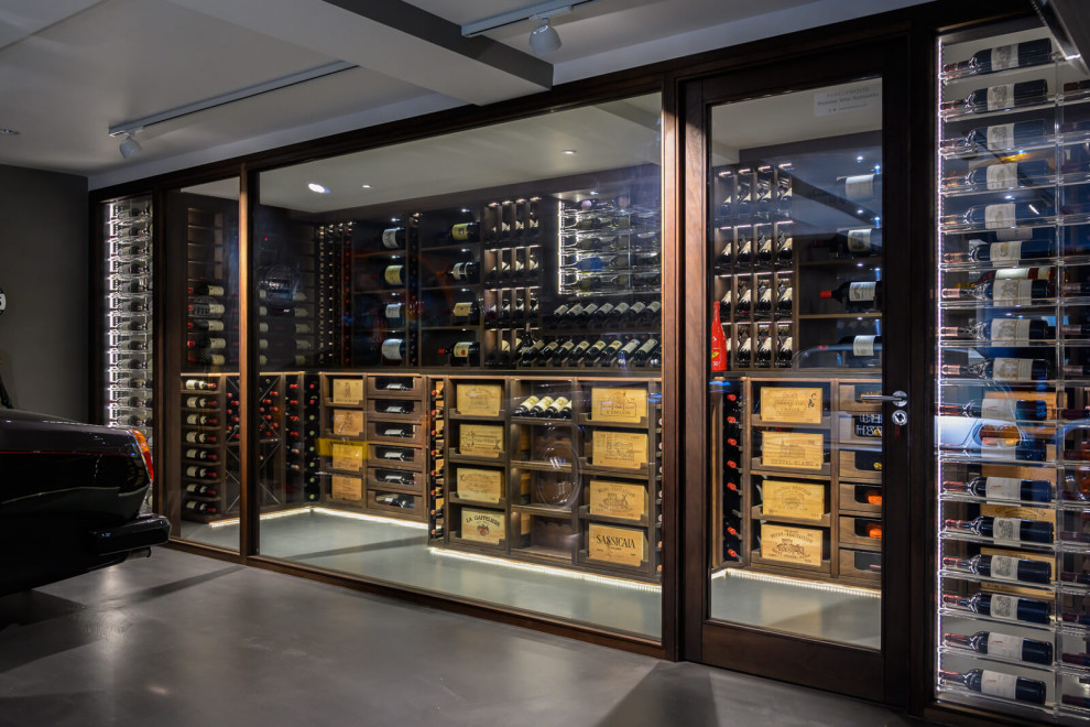 Design ideas for a mid-sized contemporary wine cellar in Essex with display racks and grey floor.