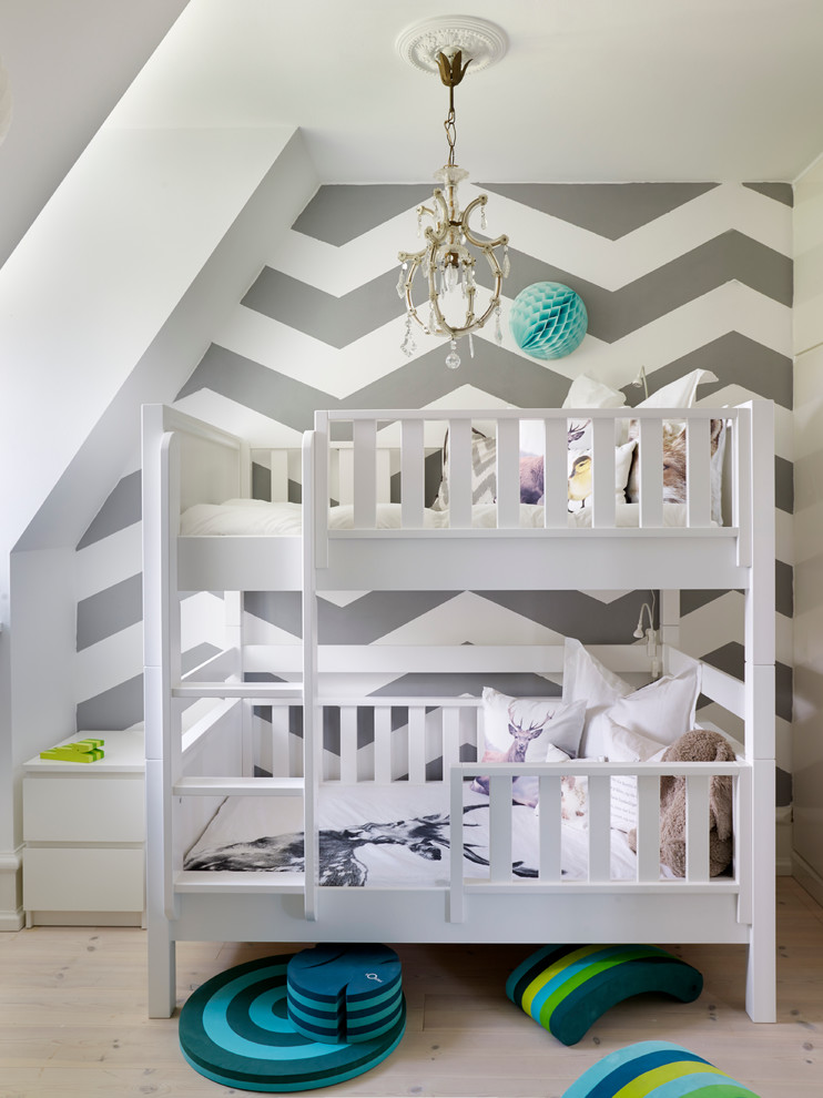 Photo of a small transitional gender-neutral kids' bedroom for kids 4-10 years old in Copenhagen with white walls and light hardwood floors.
