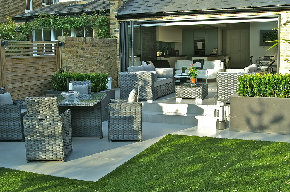Design ideas for a mid-sized contemporary backyard patio in London with a water feature and concrete pavers.