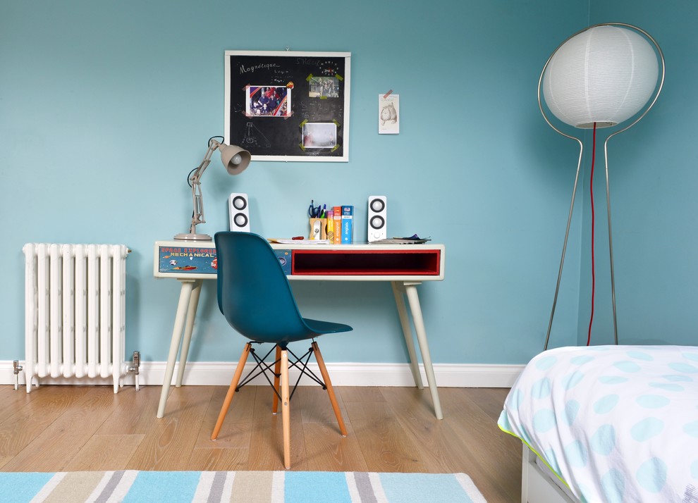 Photo of a contemporary kids' room for boys in London with blue walls and light hardwood floors.