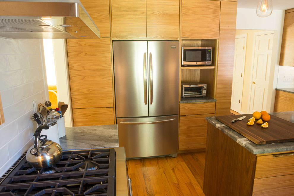Eat-in kitchen - mid-sized transitional u-shaped medium tone wood floor eat-in kitchen idea with an undermount sink, flat-panel cabinets, medium tone wood cabinets, quartzite countertops, white backsplash, ceramic backsplash, stainless steel appliances and an island