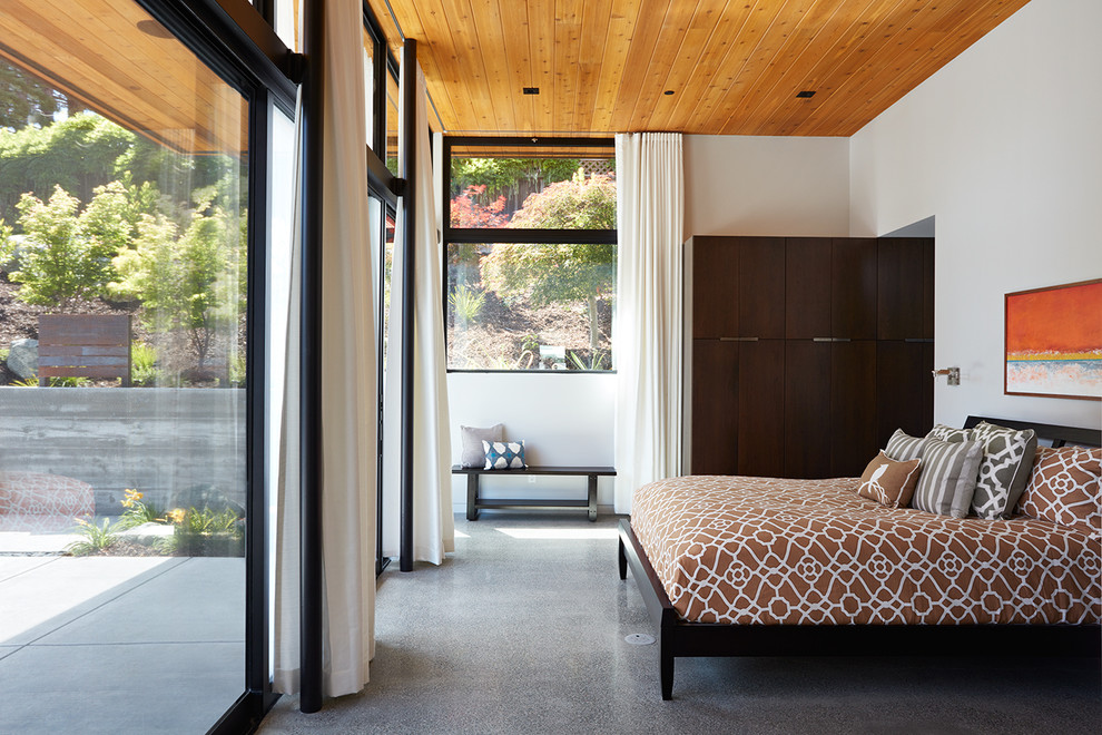 Contemporary master bedroom in San Francisco with white walls and concrete floors.