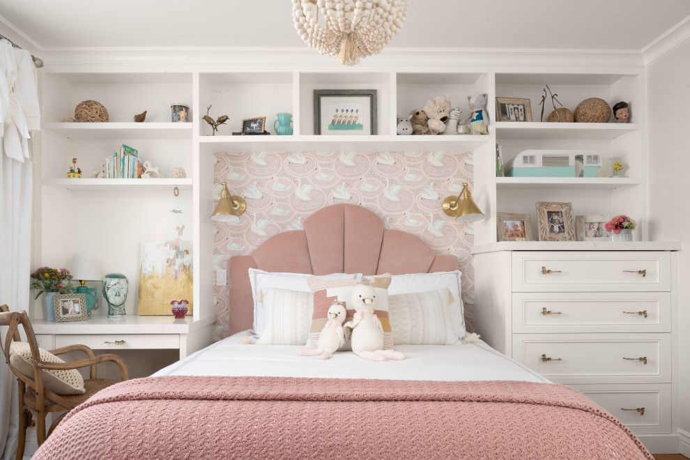 Photo of a transitional kids' bedroom for girls in San Francisco with white walls, medium hardwood floors and brown floor.