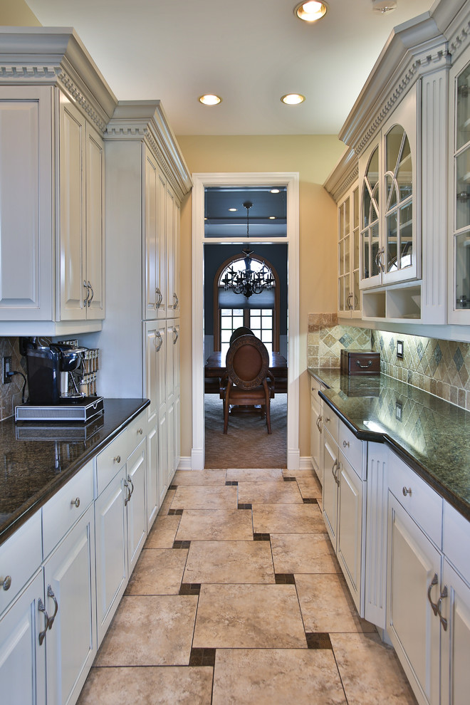 Eat-in kitchen - transitional u-shaped ceramic tile eat-in kitchen idea in Chicago with a drop-in sink, raised-panel cabinets, white cabinets, limestone countertops, beige backsplash, ceramic backsplash, stainless steel appliances and an island