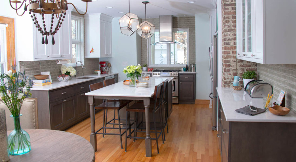 Enclosed kitchen - mid-sized transitional l-shaped light wood floor and beige floor enclosed kitchen idea with an undermount sink, glass-front cabinets, white cabinets, quartz countertops, gray backsplash, porcelain backsplash, stainless steel appliances and an island