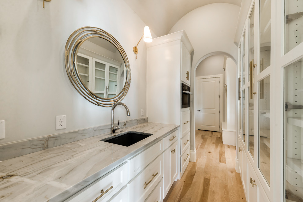 Small 3/4 bathroom in Dallas with glass-front cabinets, white cabinets, a corner shower, beige tile, beige walls, light hardwood floors, an undermount sink, engineered quartz benchtops and a hinged shower door.