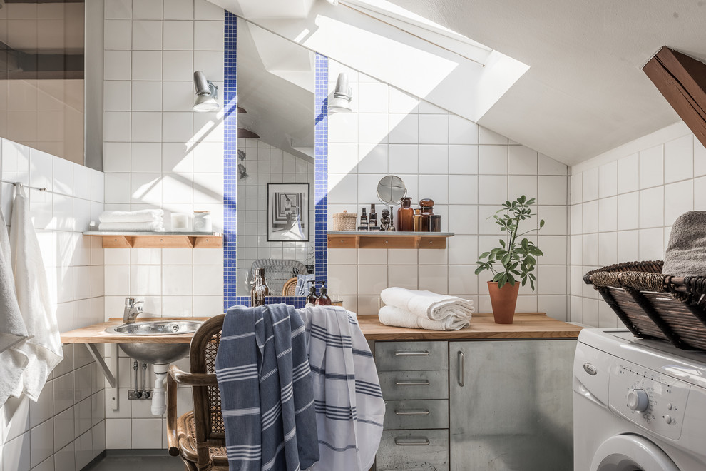 This is an example of a large industrial bathroom in Stockholm with flat-panel cabinets, grey cabinets, white walls, a drop-in sink, wood benchtops and ceramic tile.