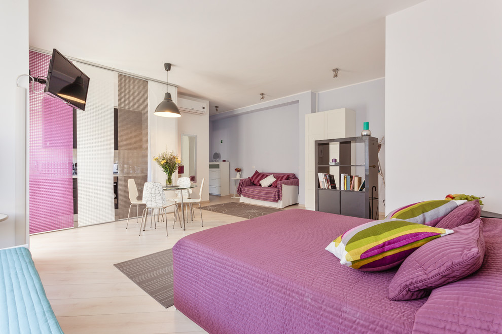 Design ideas for a mid-sized contemporary bedroom in Rome with purple walls, light hardwood floors and beige floor.