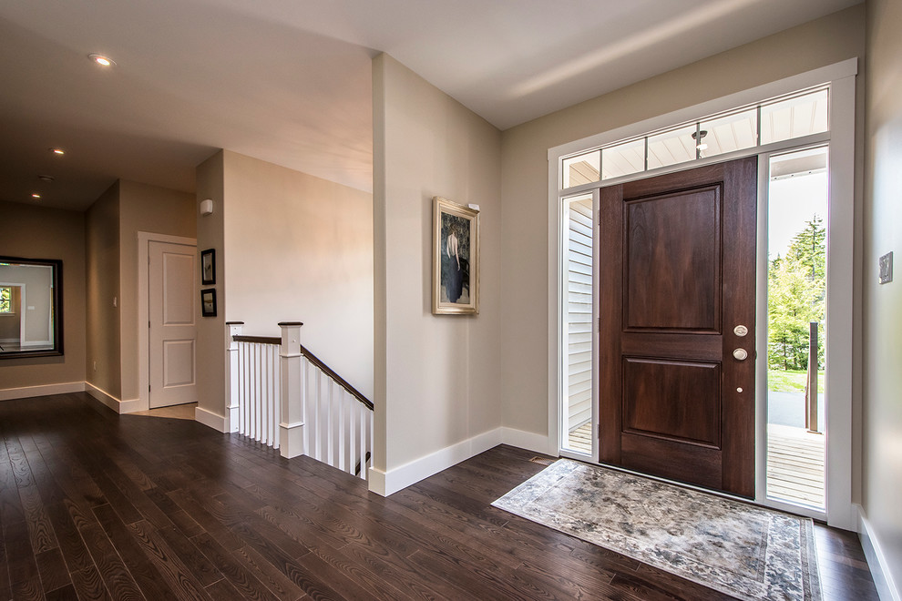 Example of a large transitional dark wood floor front door design with beige walls and a dark wood front door