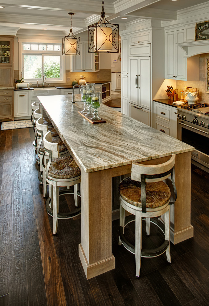 Inspiration for an expansive transitional l-shaped open plan kitchen in Other with a farmhouse sink, beaded inset cabinets, white cabinets, granite benchtops, beige splashback, mirror splashback, stainless steel appliances, dark hardwood floors, with island and multi-coloured benchtop.