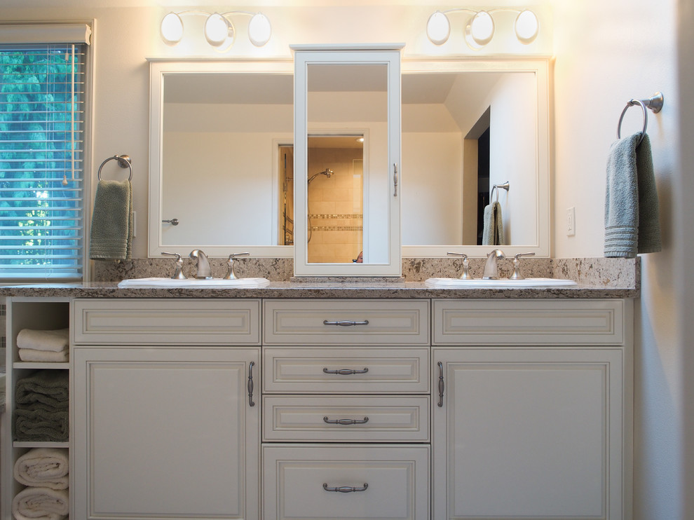 Large traditional master bathroom in Seattle with a drop-in sink, raised-panel cabinets, white cabinets, engineered quartz benchtops, a drop-in tub, an alcove shower, a two-piece toilet, beige tile, porcelain tile, white walls, porcelain floors, multi-coloured benchtops and a double vanity.