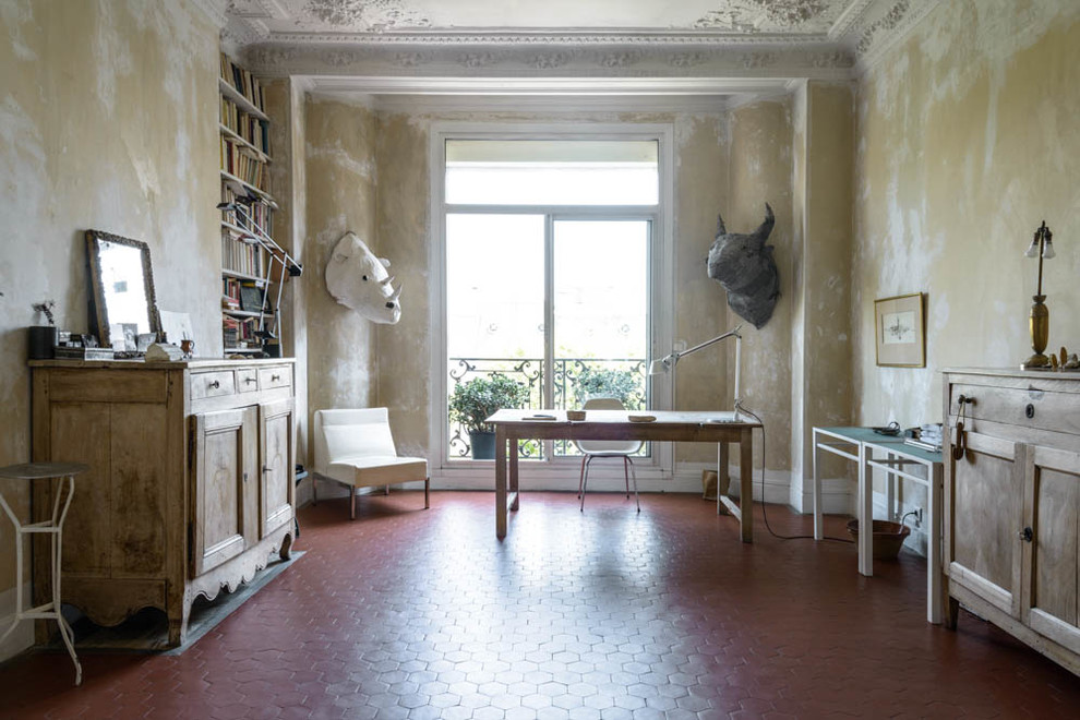 Large mediterranean study room in Marseille with beige walls, terra-cotta floors, no fireplace and a freestanding desk.