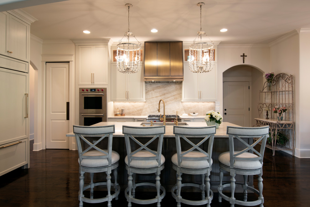 Large transitional l-shaped dark wood floor and brown floor open concept kitchen photo in Nashville with an undermount sink, beaded inset cabinets, white cabinets, quartzite countertops, beige backsplash, stone slab backsplash, stainless steel appliances, an island and beige countertops