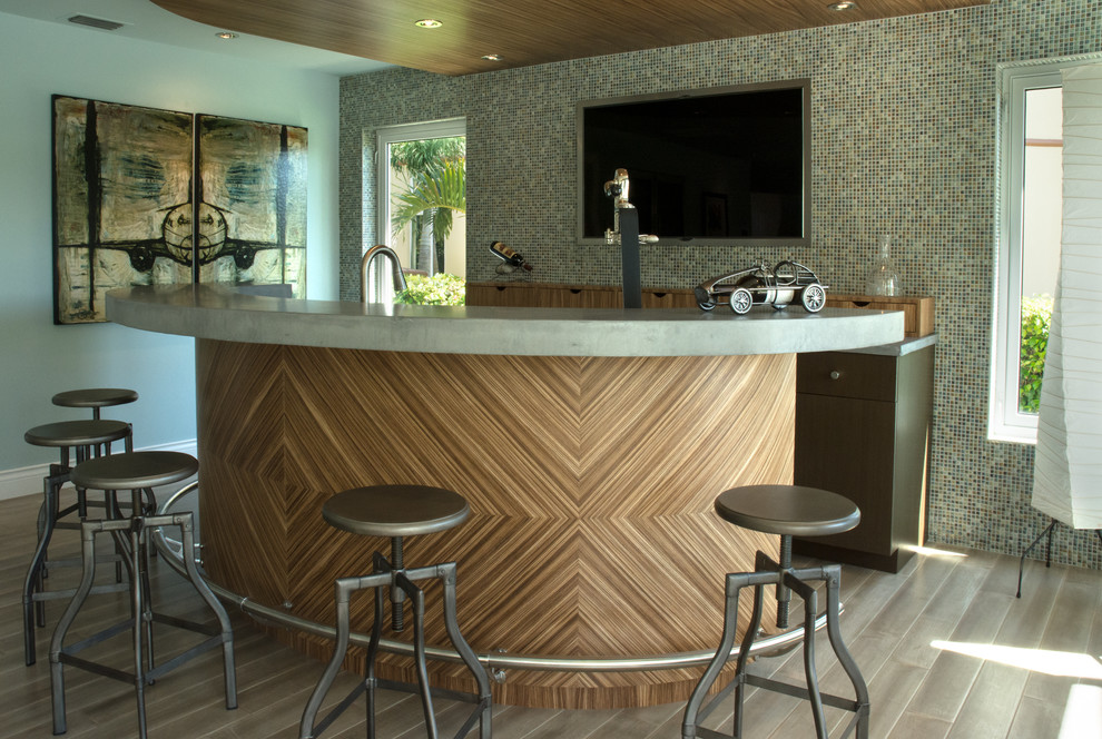 This is an example of a contemporary galley seated home bar in Miami with flat-panel cabinets, dark wood cabinets, multi-coloured splashback and mosaic tile splashback.