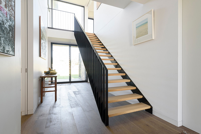 This is an example of a mid-sized contemporary wood straight staircase in Melbourne with open risers and metal railing.