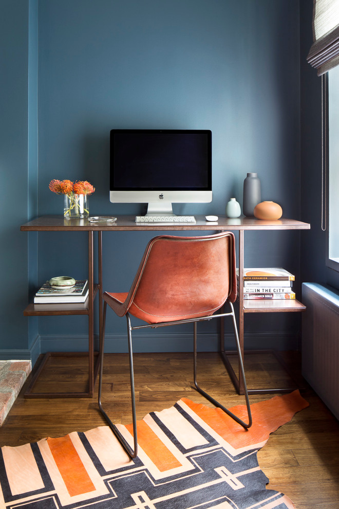 Inspiration for a small transitional study room in New York with blue walls, medium hardwood floors, a freestanding desk, no fireplace and brown floor.