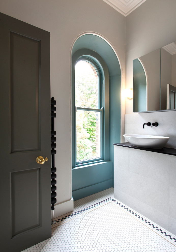 Immagine di un bagno di servizio classico con WC sospeso, pareti bianche, pavimento con piastrelle a mosaico, pavimento bianco, ante bianche e piastrelle gialle