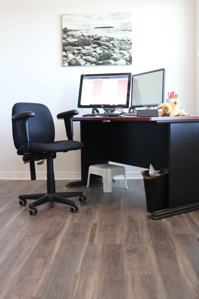 Foto de despacho actual de tamaño medio con biblioteca, suelo vinílico, escritorio independiente y suelo marrón