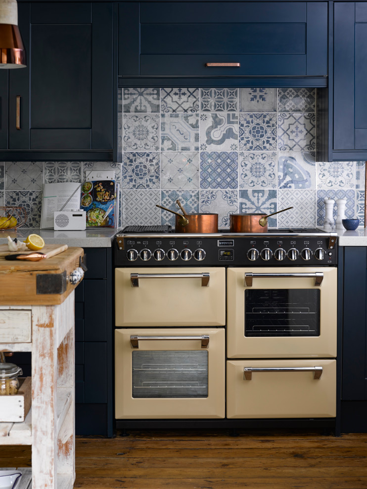 Rustik inredning av ett vit vitt kök och matrum, med bänkskiva i koppar, blått stänkskydd, stänkskydd i keramik och mellanmörkt trägolv
