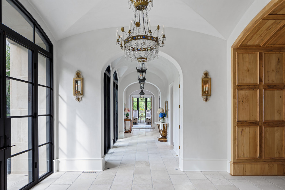 Inspiration for a large traditional foyer in Other with white walls, limestone floors, a metal front door, beige floor, wood walls and a double front door.