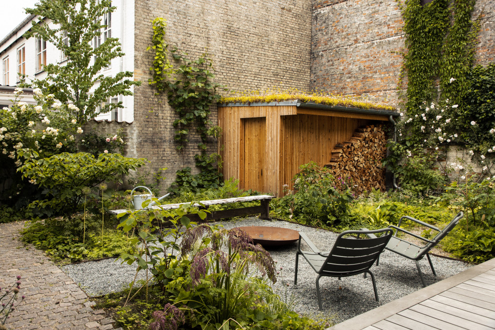 This is an example of a contemporary patio in Copenhagen with a fire feature and no cover.