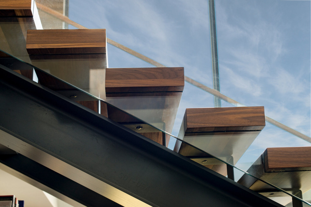Exempel på en mycket stor modern flytande trappa i trä, med öppna sättsteg och räcke i glas