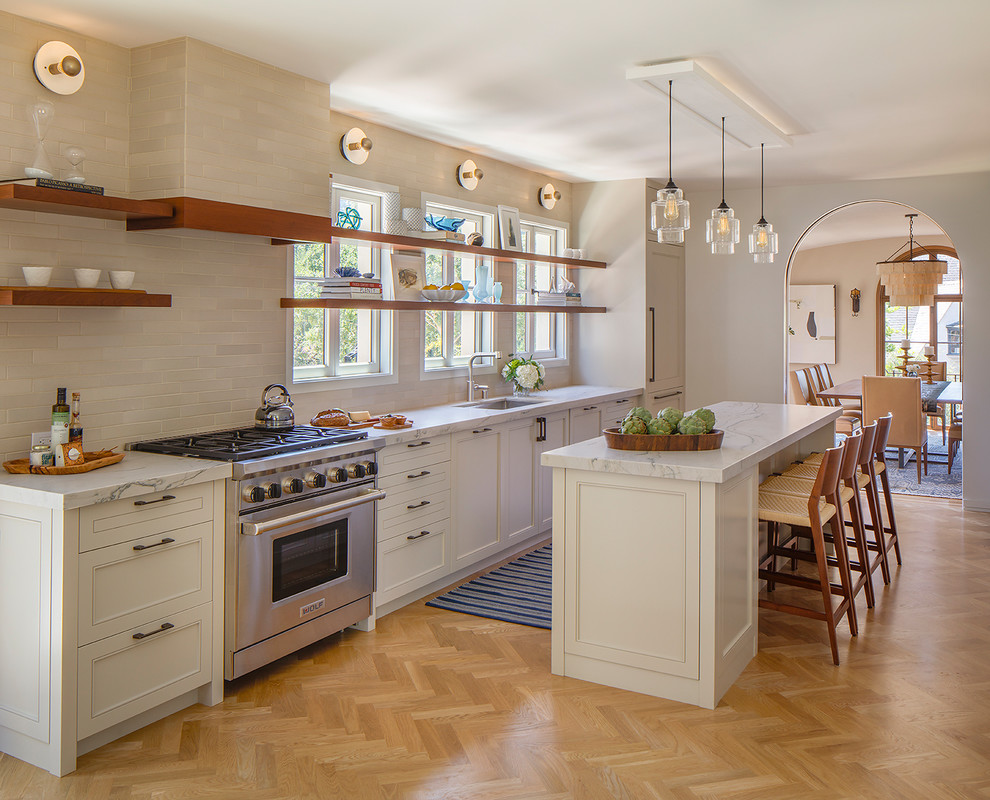 Photo of a transitional kitchen in San Francisco with an undermount sink, open cabinets, window splashback, stainless steel appliances, light hardwood floors and with island.