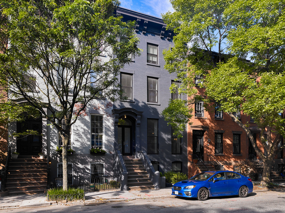 Design ideas for a large traditional three-storey brick grey townhouse exterior in New York with a flat roof.