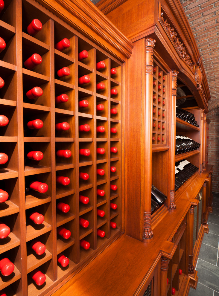 This is an example of an expansive traditional wine cellar in New York with ceramic floors, display racks and grey floor.