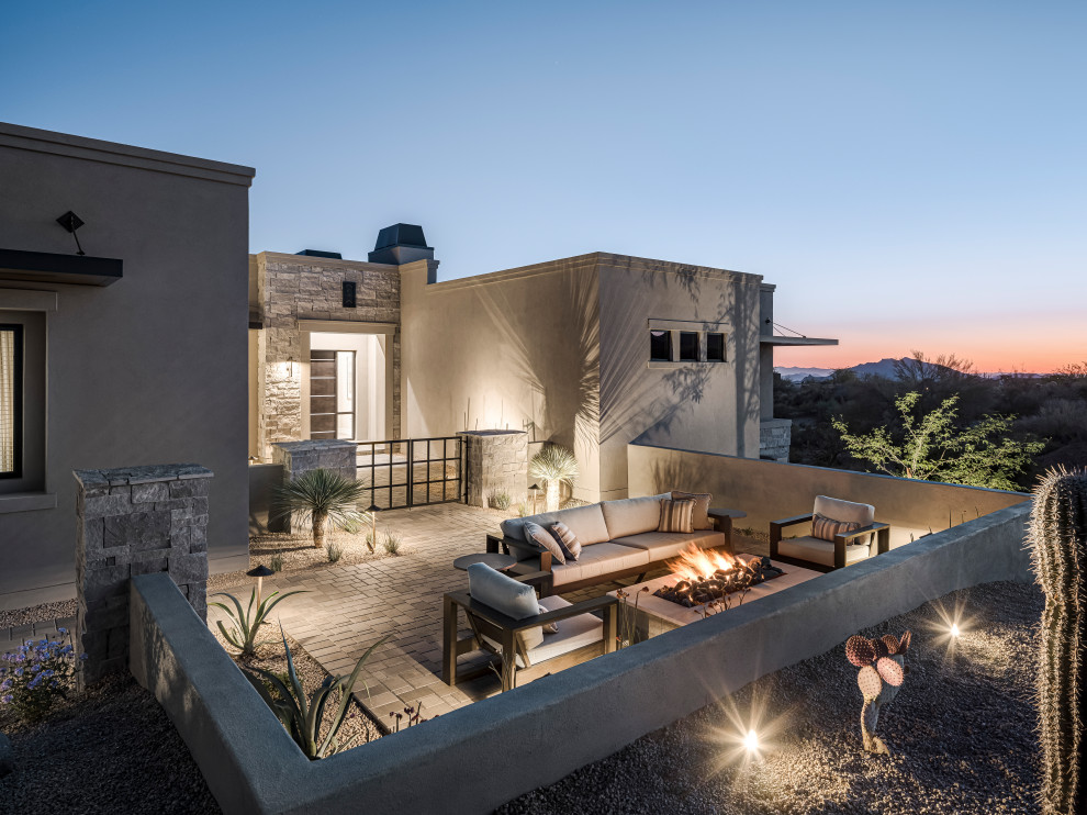 Inspiration for a large mediterranean gray one-story stucco exterior home remodel in Phoenix with a black roof