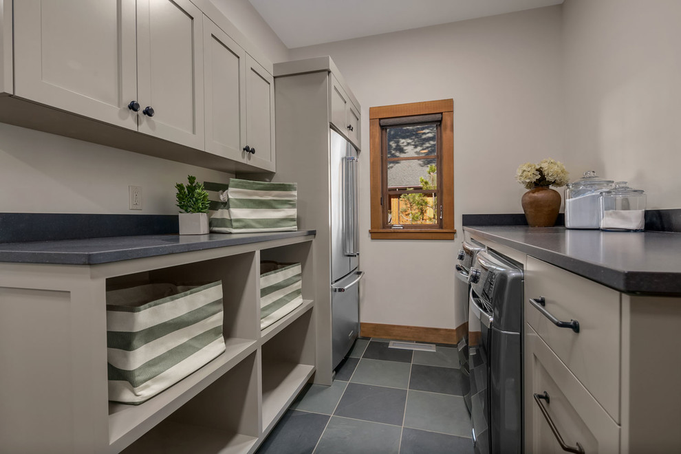 Mid-sized traditional laundry cupboard in Seattle with open cabinets, granite benchtops, beige walls, marble floors and a side-by-side washer and dryer.